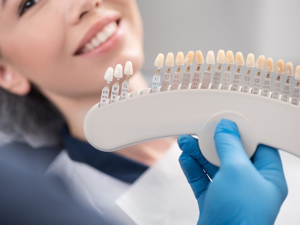 Odontologist arms showing teeth implants to patient