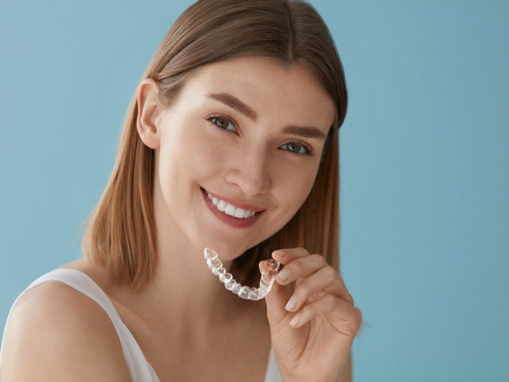 Teeth whitening. Woman with healthy teeth using removable braces